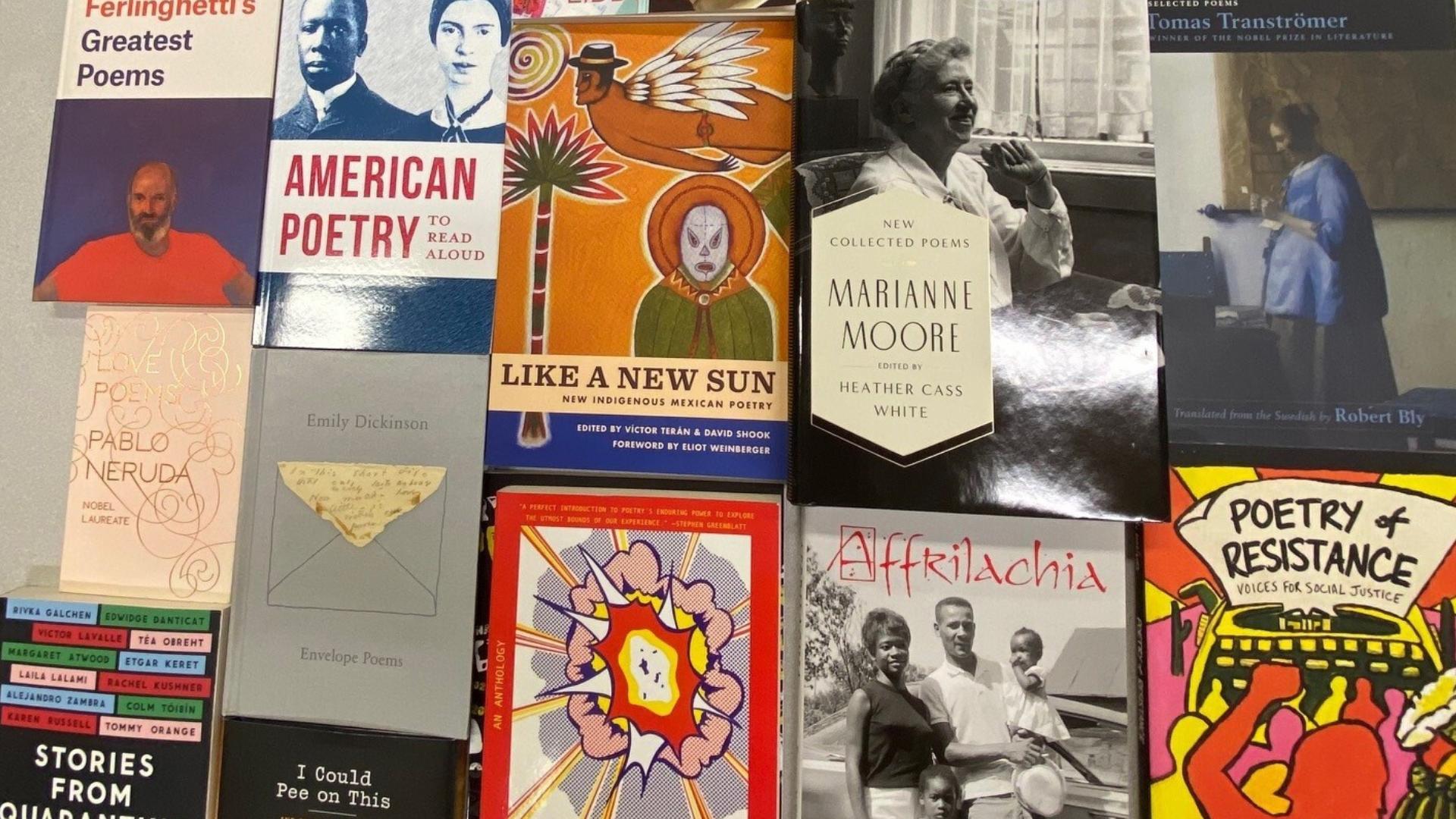 Various books about poetry sitting on a table.